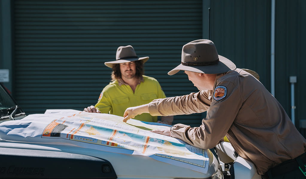 2 NPWS Rangers looking at a map. Credit: Remy Brand &copy; DPE