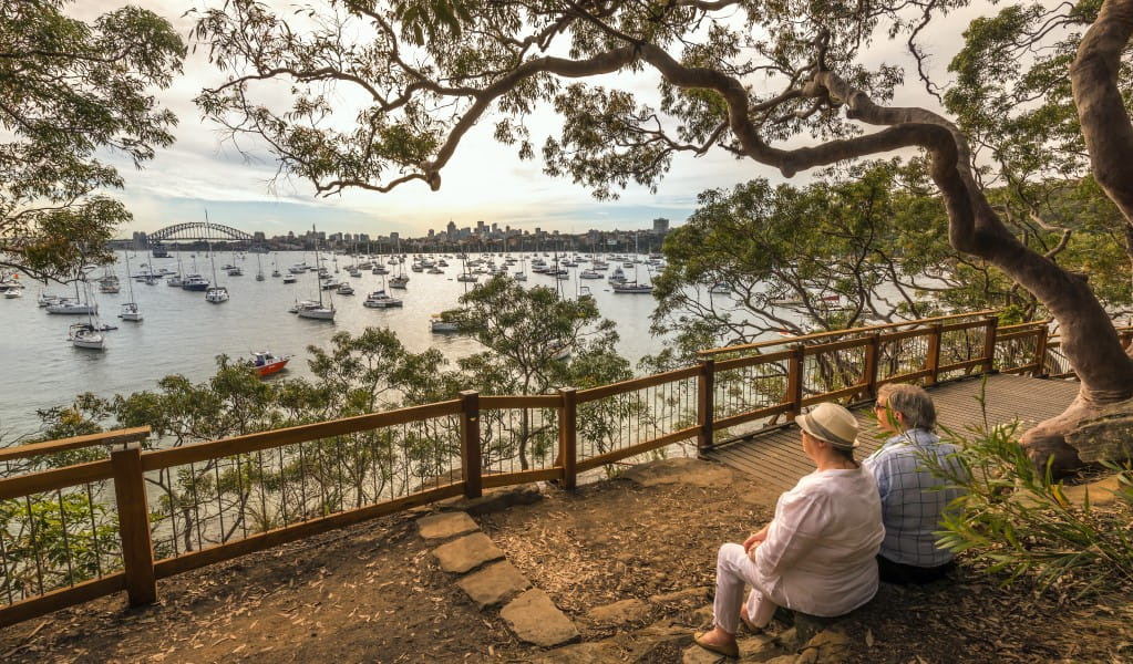A couple on a park bench, enjoying the International Fleet Review celebrations at Bradleys Head in Sydney Harbour National Park. Photo: John Spencer &copy; OEH