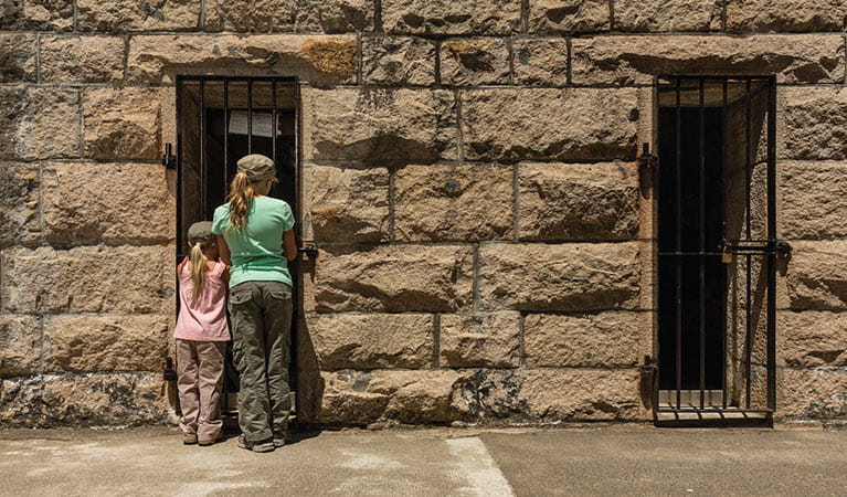 Image of children peering in the window of an old gaol cell at Trial Bay Gaol 