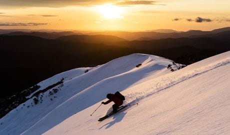 Skiier moving down slope with sunset in background. Photo: Dylan Robinson &copy; Blizzard Academy