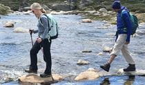 2 people crossing a river on a hiking tour in Kosciuszko National Park with Wilderness Sports. Photo: Bruce Easton &copy; Wilderness Sports
