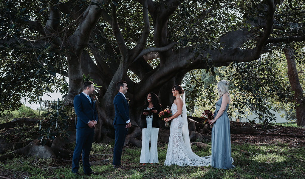 Couple exchanging vows alongside celebrant and bridesmaid, Sydney Harbour National Park. Photo: Matthew Horspool &copy; DPIE