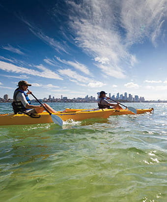 People wearing sunhats, sun protection, paddling their kayaks off Bradleys Head. Credit: David Finnegan/DPE &copy; OEH