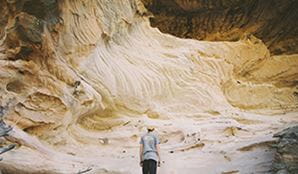 A young man looking with awe at the sandstone caves in Pilliga Nature Reserve. Photo: Harrison Candlin