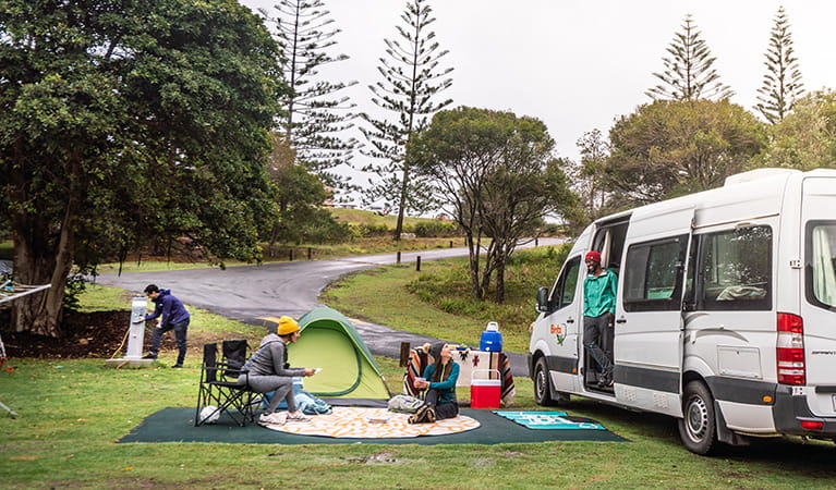 Campers picnicking next to their campervan at Trial Bay Gaol campground, Arakoon National Park. Photo: Rob Mulally/DPIE