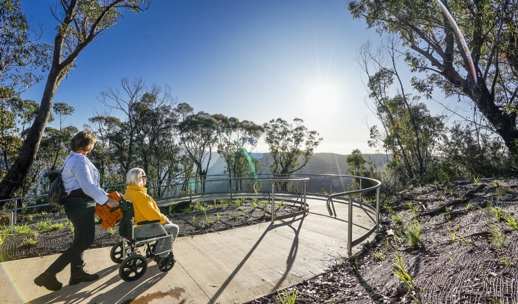 2 visitors heading down the accessible ramp towards Evans lookout in Blue Mountains National Park. Photo: Simone Cottrell/DPE &copy; DPE