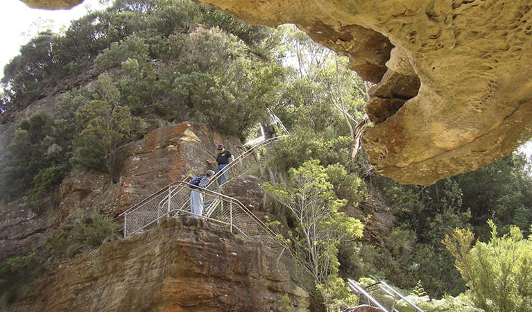 Wide view of 2 people descending a steep section of the Giant Stairway with steel railing. Photo: Stephen Alton &copy; OEH