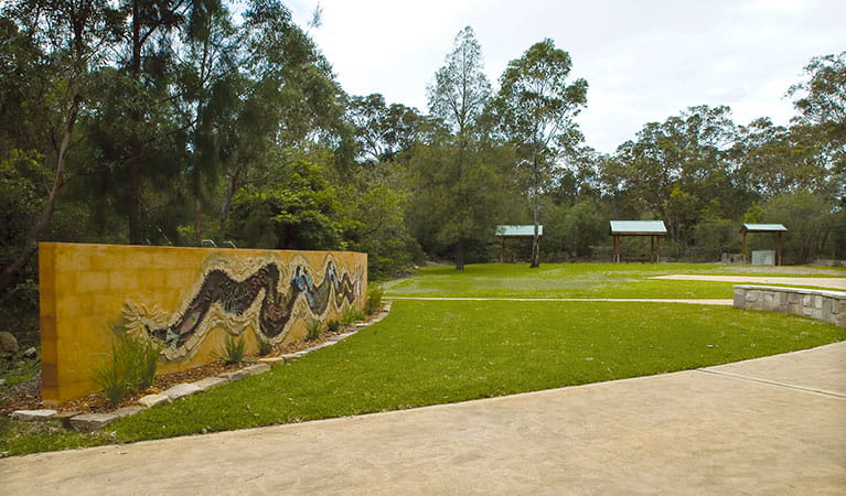 Community art mural at the entrance to Bomaderry Creek Regional Park with picnic shelters in the background. Photo: Michael Van Ewijk &copy; DPIE
