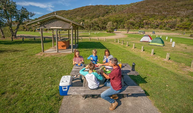 A family enjoys a barbecue lunch at The Ruins campground and picnic area. Photo credit: John Spencer &copy; DPIE