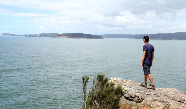Man looks out at the water from a rock. Photo: John Yurasek &copy; OEH