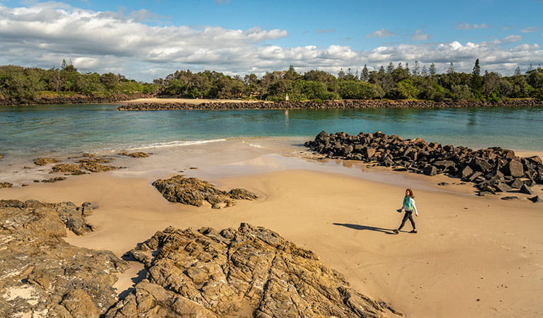 Woman walking along the beach at North Head walking track in Brunswick Heads Nature Reserve. Photo: John Spencer &copy; OEH