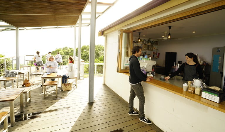 Visitor buying a coffee at Cape Byron Lighthouse Cafe. Photo: John Spencer/OEH