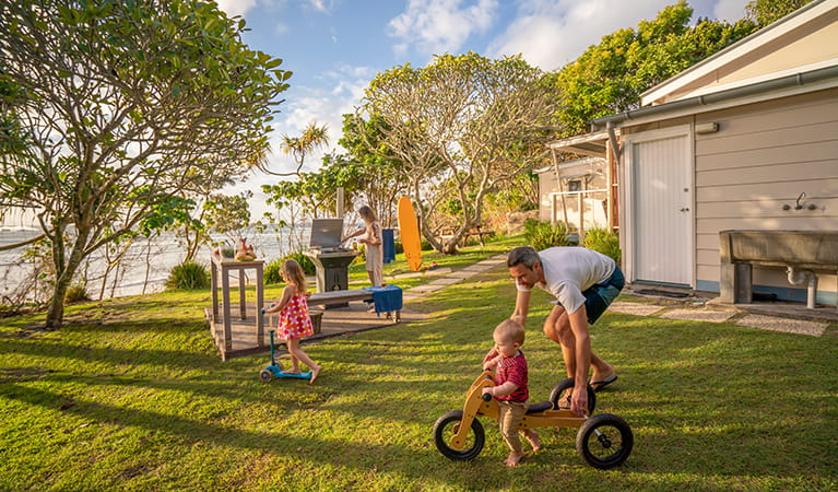 Family in the garden overlooking Byron Bay beach from Partridge Cottage. Photo: DPIE/John Spencer