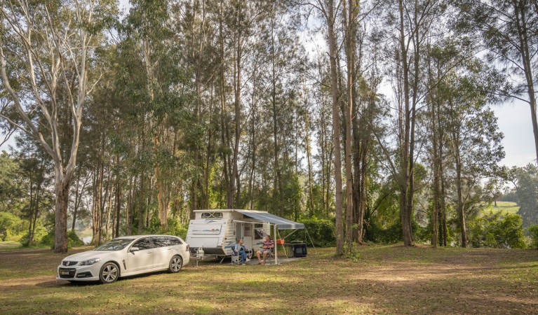 A couple sit outside their caravan at Cattai campground in Cattai National Park, on the Hawkesbury River. Photo: John Spencer/OEH