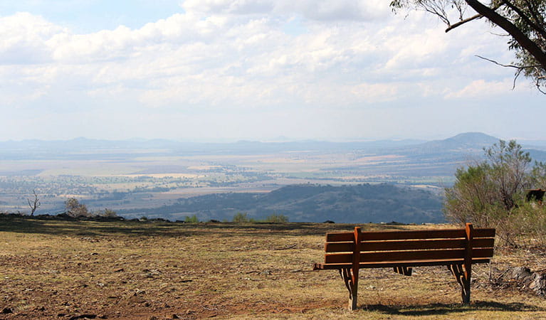  Grassy lookout area with park bench, set against wide views of plains and mountains. Photo: Jessica Stokes &copy; Jessica Stokes