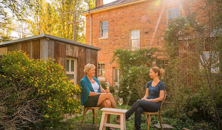 Two women enjoy a drink in the garden at Hosies, Hill End Historic Site. Photo: J Spencer/OEH