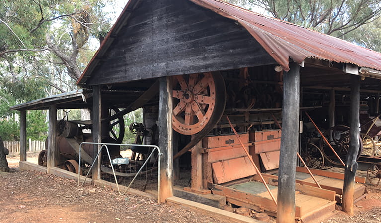 Rustic wood shed with metal roof containing historic farm machinery.  Photo: Brett Kearins/DPIE