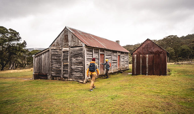 Two men outside a timber and tin building at Coolamine Homestead in Kosciuszko National Park. Photo: Robert Mulally/DPIE