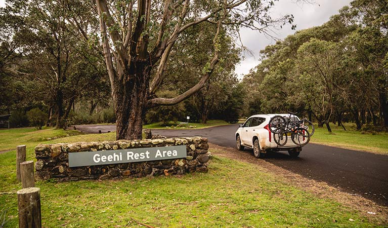 A car with bike rack passes a sign at Geehi Flats picnic area and campground, Kosciuszko National Park. Photo: Daniel Tran/OEH