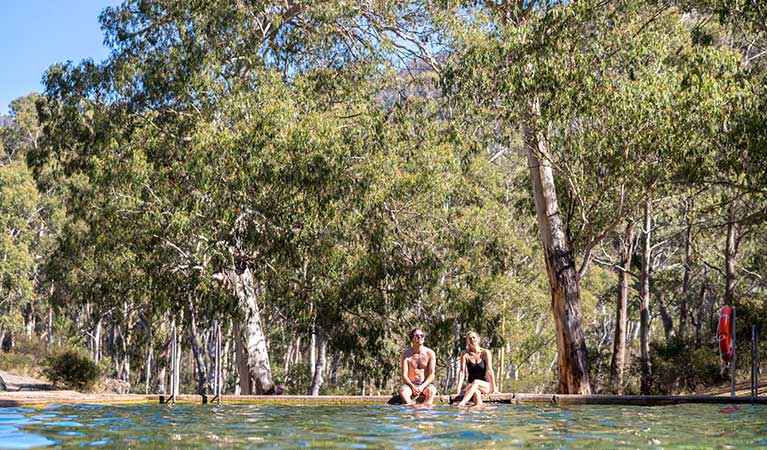 A couple sit by the thermal pool, Yarrangobilly area in Kosciuszko National Park. Photo: Boen Ferguson/OEH.