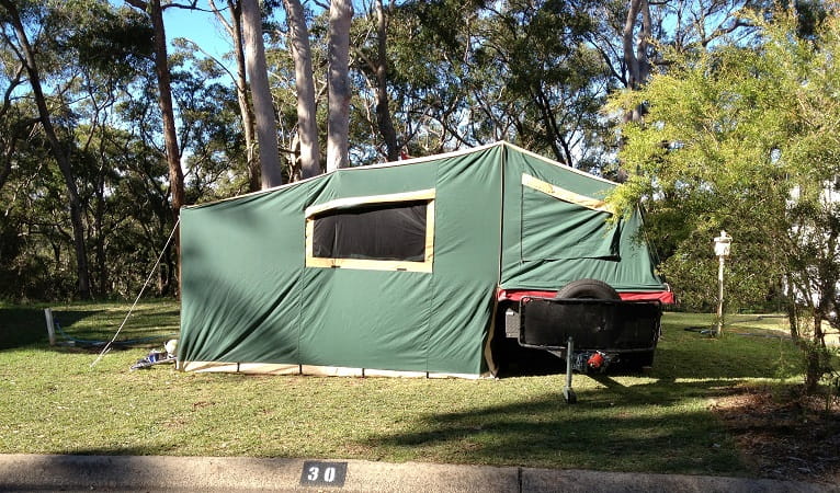A large green camper trailer set up on a grassy area at Lane Cove caravan park. Photo: Claire Franklin/OEH