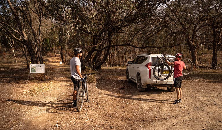 Two men take bikes off the back of a car at the start of a multi-use track in Livingstone National Park. Photo: Robert Mulally/DPIE