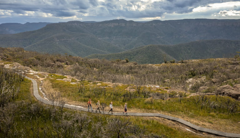 A group of people on walking track with view of mountains in the background. Photo: John Spencer