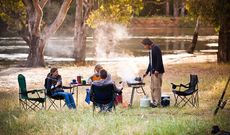 Friends cooking dinner at Quicks Beach campground. Photo: David Finnegan/NSW Government