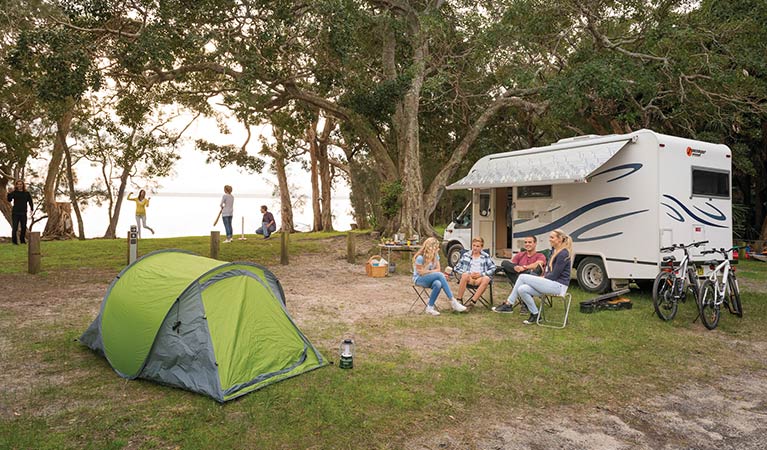 A group of friends sitting beside their campervan at Mungo Brush campground. Photo: John Spencer/OEH