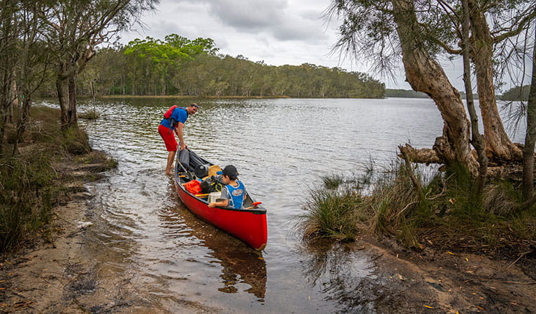 2 people in a canoe on Boolambayte Lake at Violet Hill campground in Myall Lakes National Park. Photo: John Spencer &copy; DPIE
