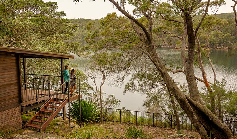 A couple stand on the balcony of Weemalah Cottage, Royal National Park. Photo: John Spencer/OEH