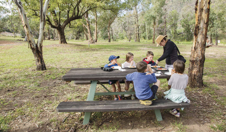 An adult and group of kids having lunch at a picnic table in Warrumbungle National Park. Photo: Simone Cottrell &copy; shared OEH and photographer
