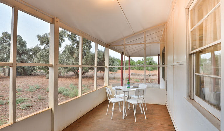 Enclosed verandah with table and chairs at Willandra Cottage, Willandra National Park. Photo: Vision House Photography/DPIE