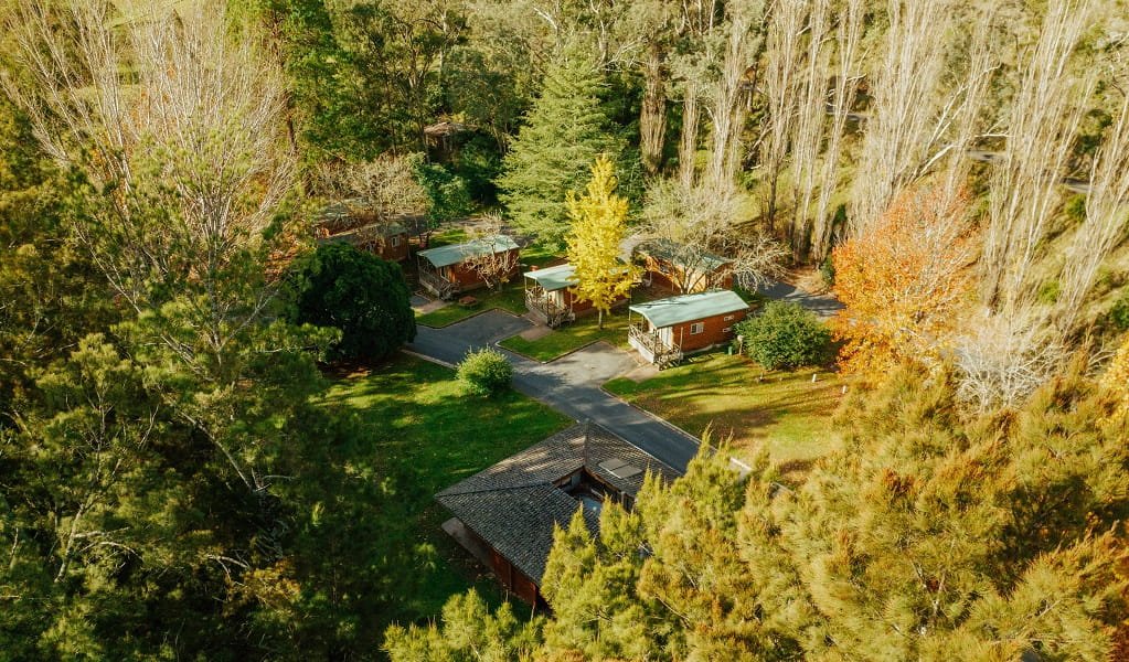 Aerial view of Wombeyan Caves cabins, which are set in a clearing surrounded by tall trees. Credit: Remy Brand/DPE &copy; Remy Brand