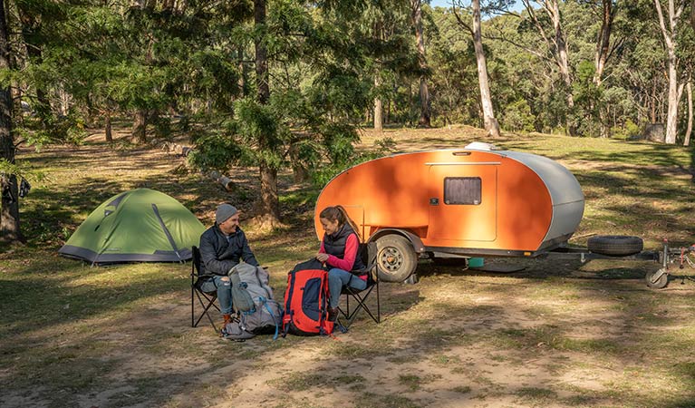 A couple preparing for a hike in front of their mini camper trailer at Private Town campground, Yerranderie Regional Park. Photo: John Spencer/OEH