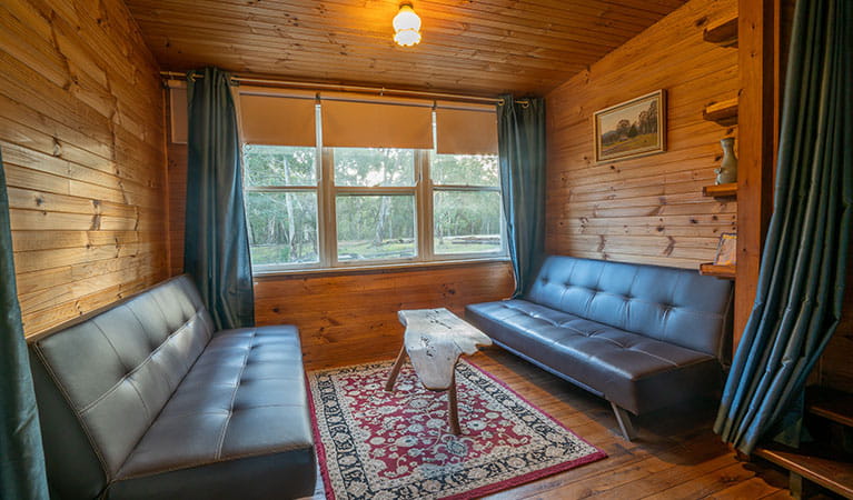 Two lounges and a wooden coffee table in Slippery Norris Cottage, Yerranderie Regional Park. Photo: John Spencer/OEH