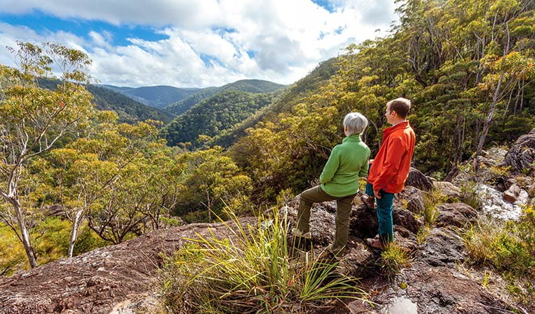 A couple looking out over the mountain range, Gibraltar Range National Park. Photo: Rob Cleary