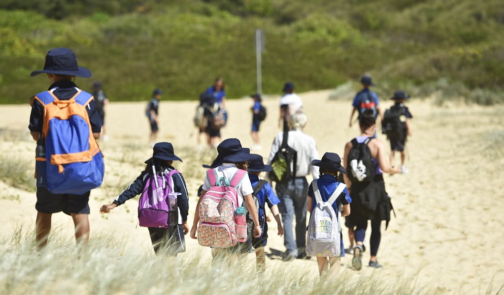 Students walking in the grass, led by an NPWS guide, Glenrock State Conservation Area. Photo: Adam Hollingworth &copy; DPE