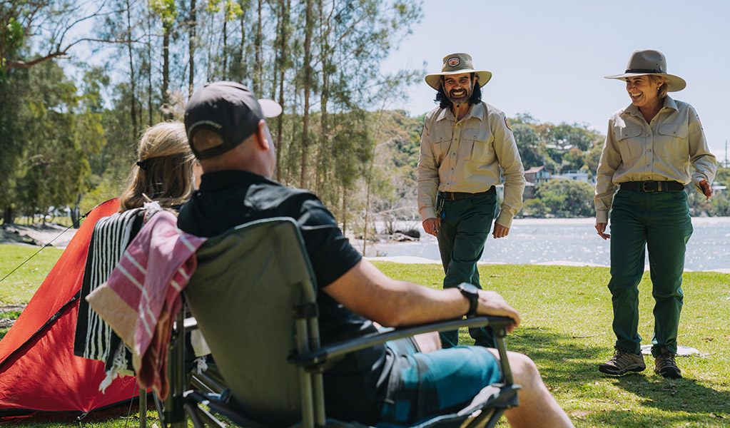 NPWS Rangers at a park greeting campers in camp chairs. Credit: Remy Brand &copy; DPE