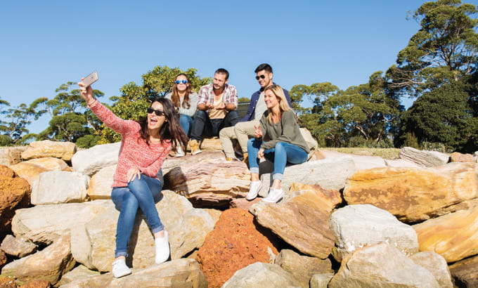 Young friends snap a photo at Bonnie Vale, Bundeena, Royal National Park. Photo: Simone Cottrell/OEH.