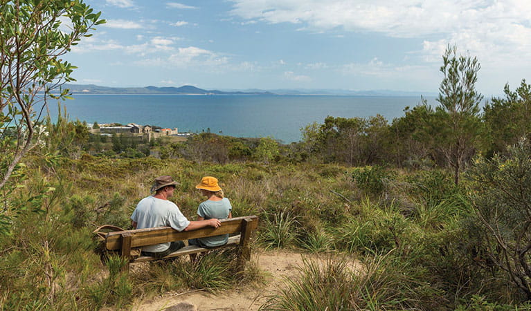 A couple rest on a picnic bench with an ocean view on Monument track. Credit: David Finnegan &copy; David Finnegan/DPIE