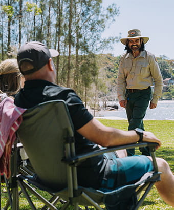 NPWS Rangers at a park greeting campers in camp chairs. Credit: Remy Brand &copy; DPE
