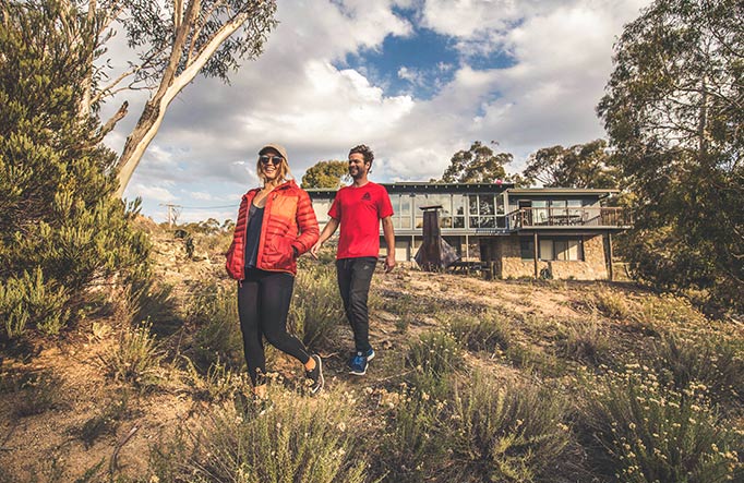 A couple walk outside Creel Lodge, Kosciuszko National Park. Photo: Boen Ferguson/OEH.