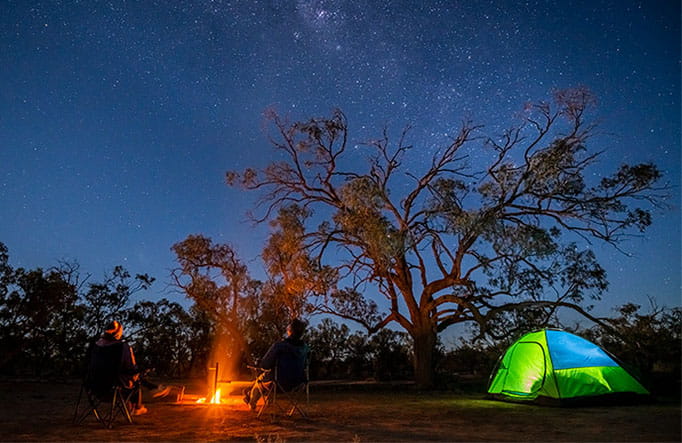 People stargazing beside a campfire at Emu Lake campground, Kinchega National Park. Photo: John Spencer &copy; DPE