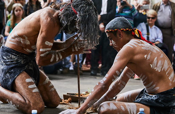 Two men share an Aboriginal cultural technique of fire starting with visitors. Photo credit: Flash Point Labs &copy; Tribal Warrior