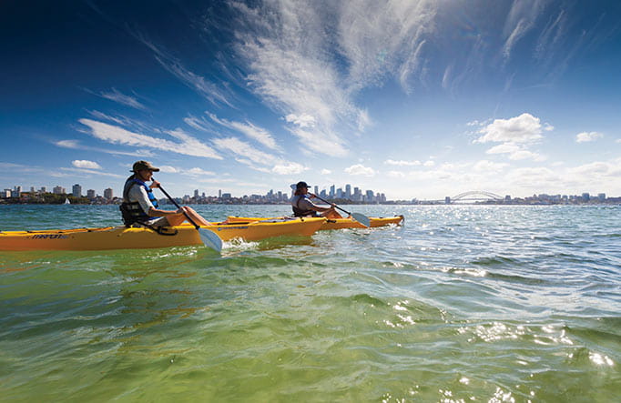 People wearing sunhats, sun protection, paddling their kayaks off Bradleys Head. Photo: David Finnegan/DPIE