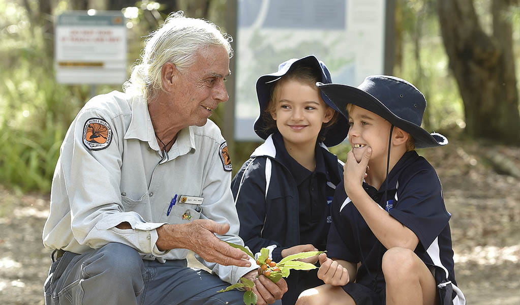 An Aboriginal guide talking to a pair of students on an Aboriginal culture school excursion in Hunter Wetlands National Park. Photo: Adam Hollingworth © DPE