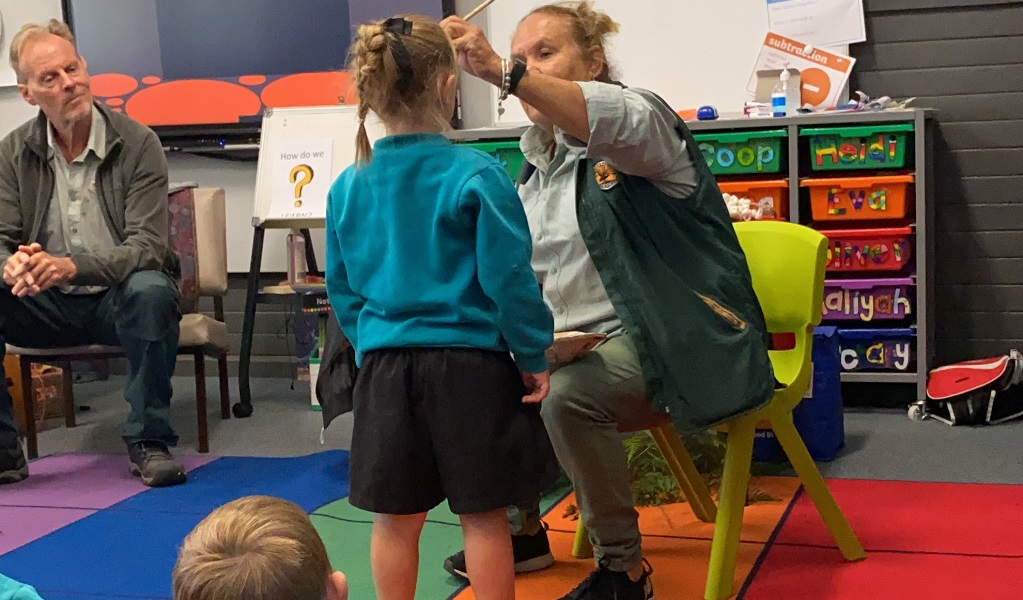 NPWS Aboriginal guide paints a young student's face. Photo: Wolumla PS. &copy; OEH