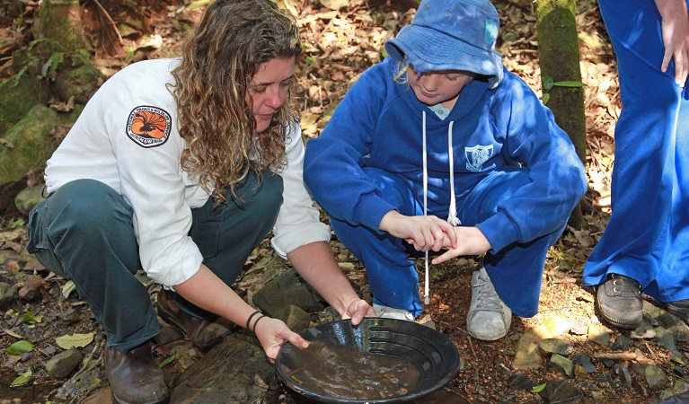 An NPWS ranger shows a student how to pan for gold, Copeland Tops State Conservation Area. Photo: Shani Milgate/OEH