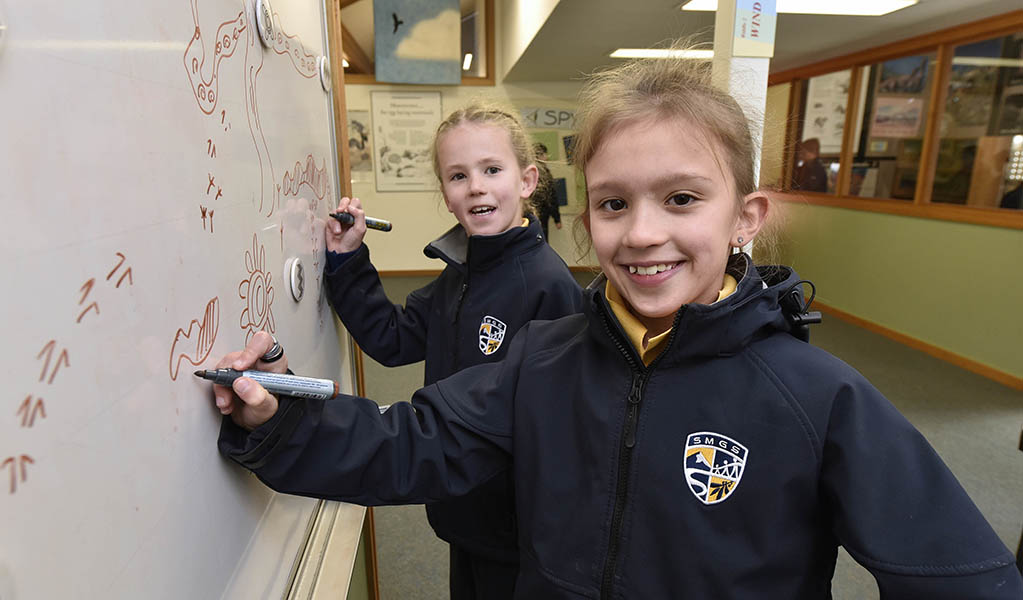 Two students working on a whiteboard in the Kosciuszko Education Centre in Kosciuszko National Park. Photo: Adam Hollingworth &copy; DPE
